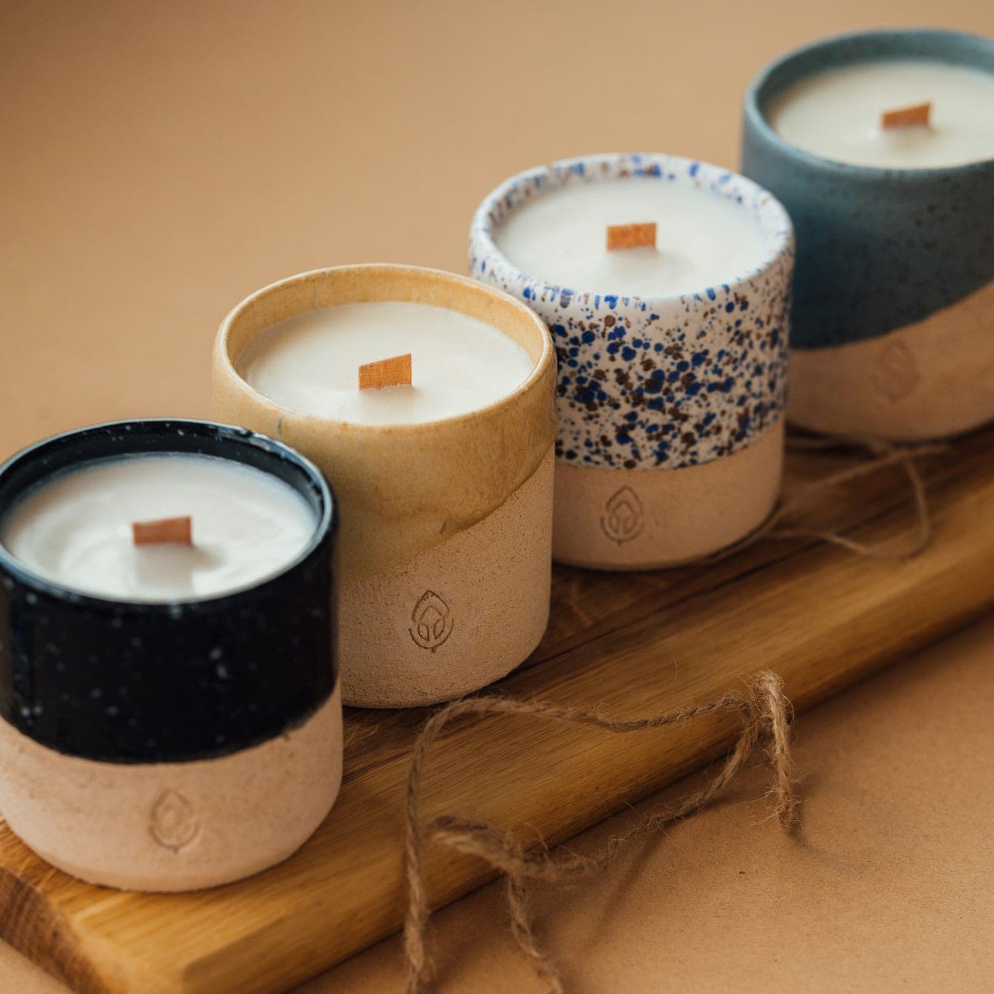 Relaxation Gift Set — Four hand-poured candles in glazed ceramic cups lined up on an oak board